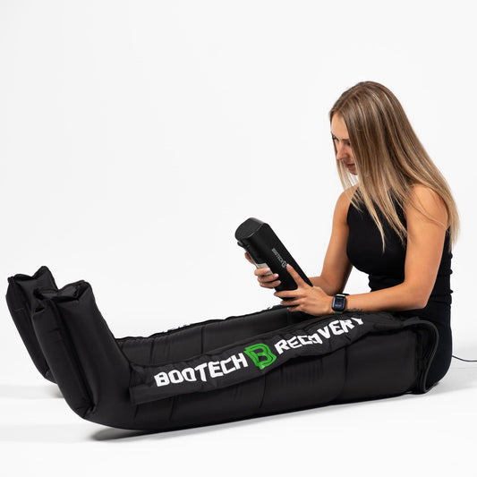 Mujer usando presoterapia Bootech Recovery para recuperación muscular en casa