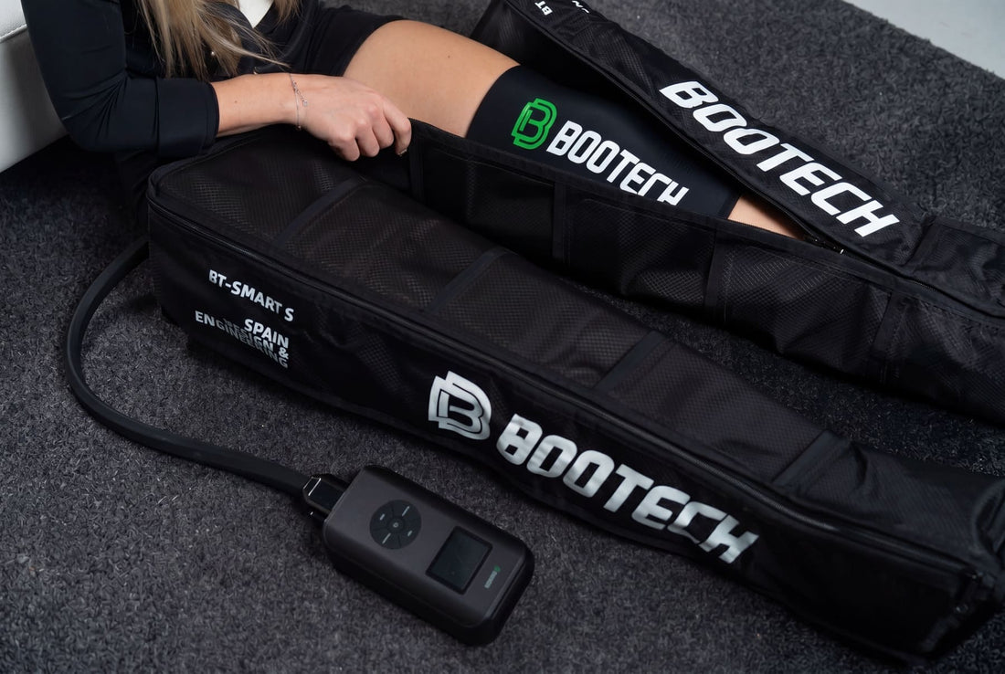 Persona utilizando botas de presoterapia en casa para recuperar las piernas después de entrenar.