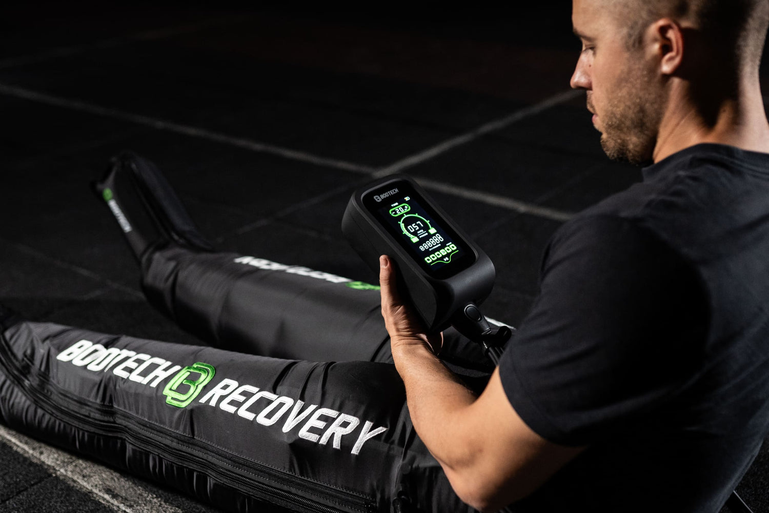 Hombre usando presoterapia Bootech Recovery para recuperación deportiva en casa