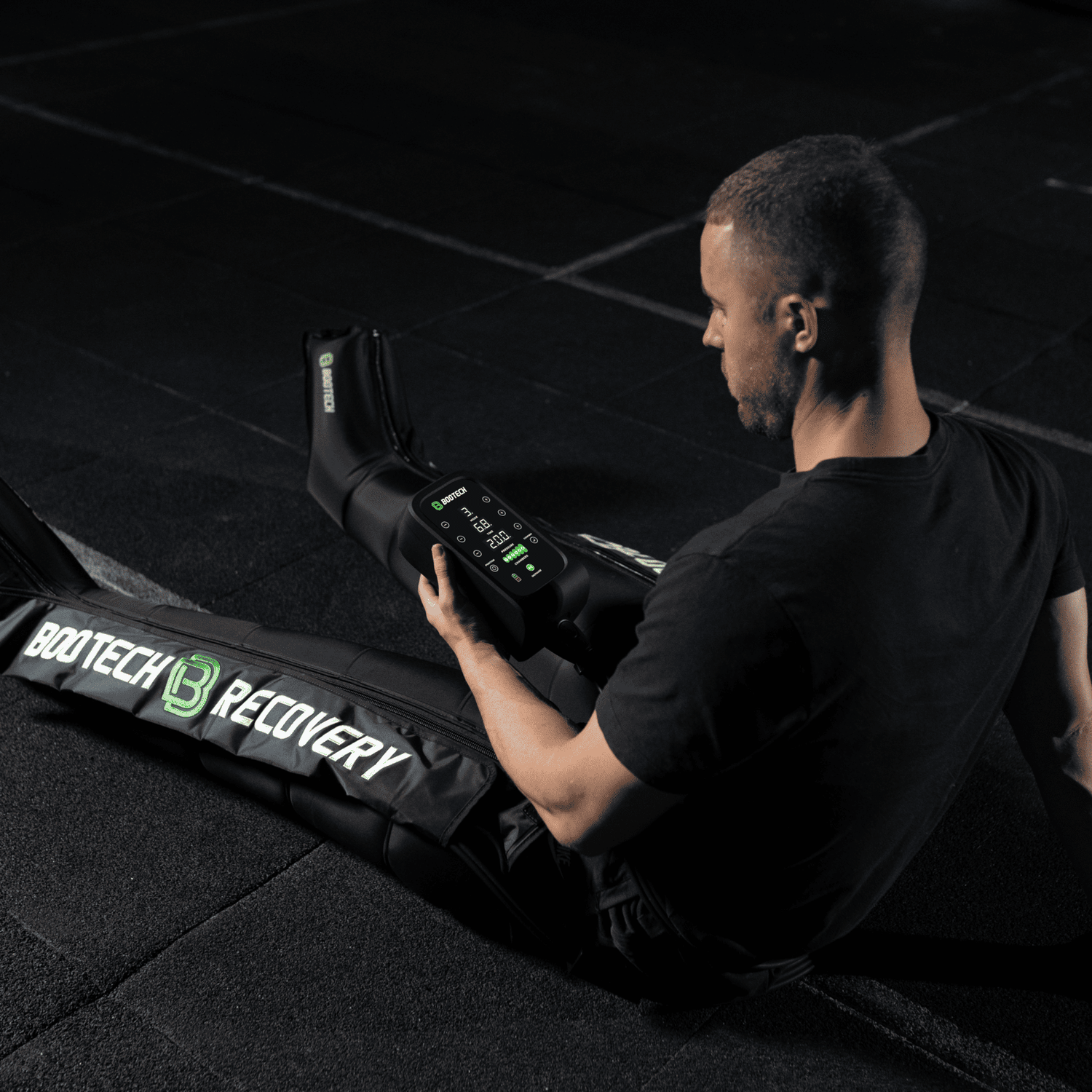Hombre usando presoterapia Bootech Recovery para recuperación deportiva en casa