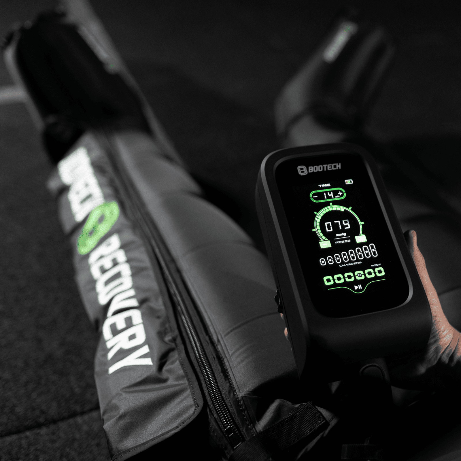 Dispositivo de presoterapia Bootech con botas de recuperación deportiva en fondo oscuro