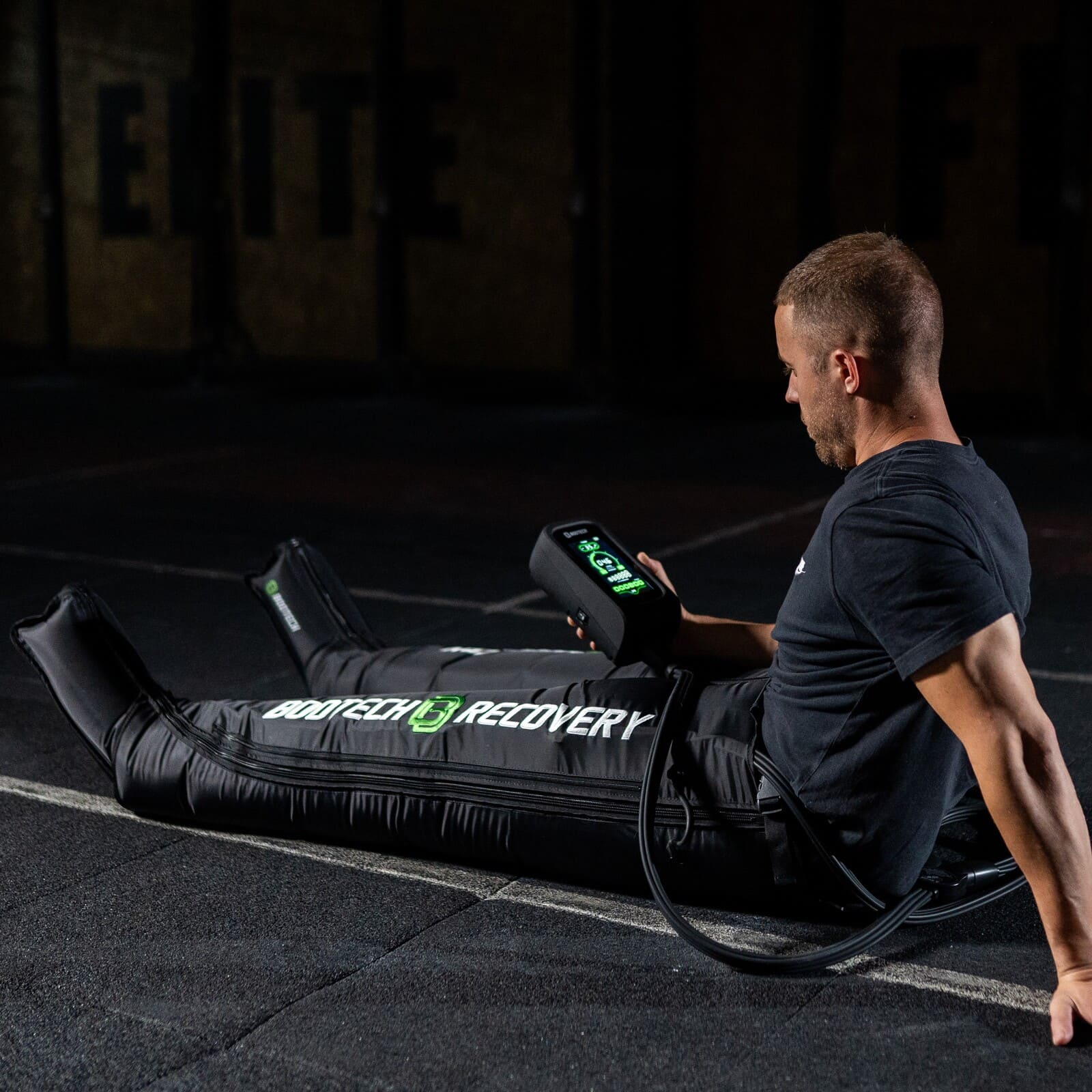 Hombre usando pantalones de presoterapia BOOTECH para recuperación deportiva en gimnasio