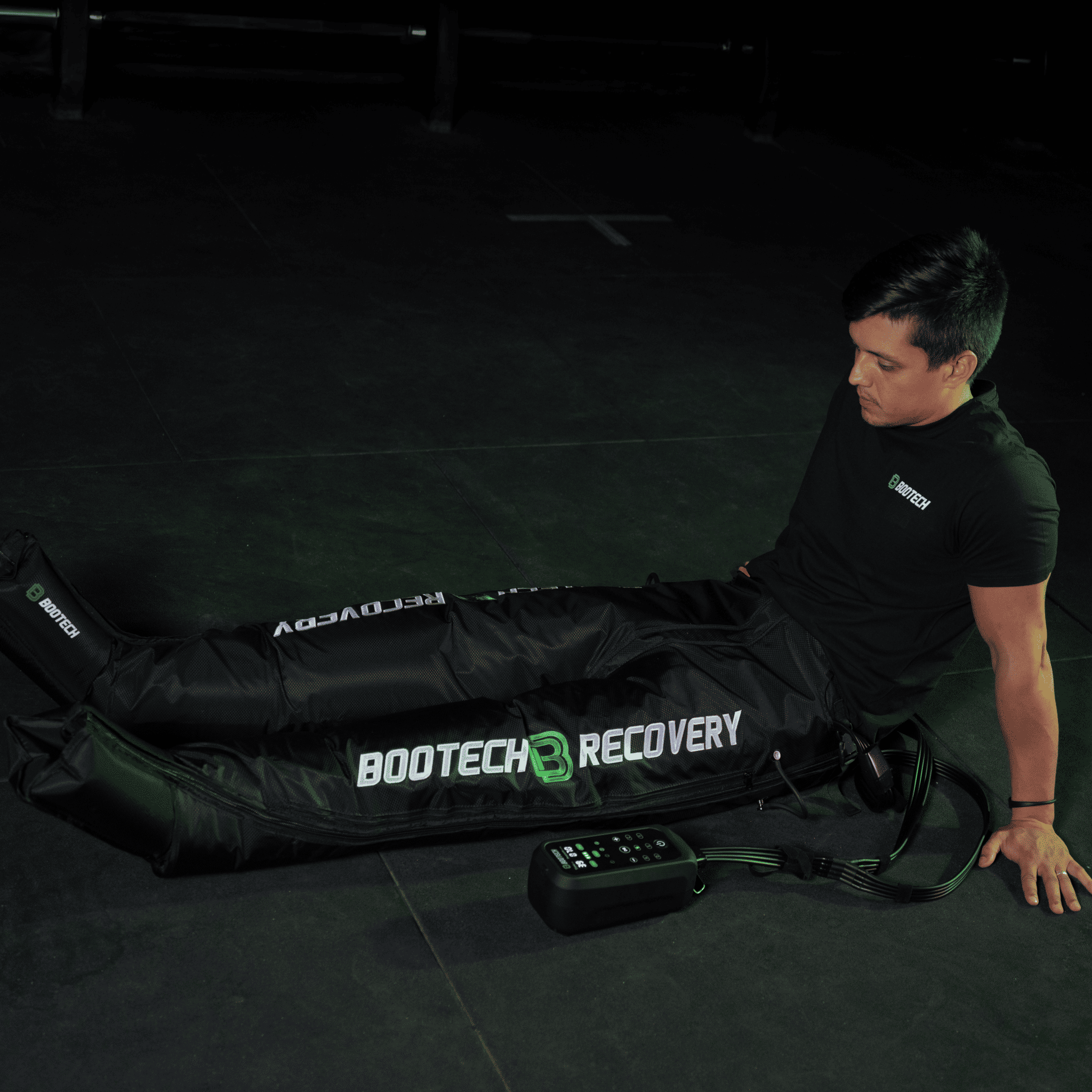 Hombre usando presoterapia BOOTECH Recovery para piernas en casa, recuperación deportiva.
